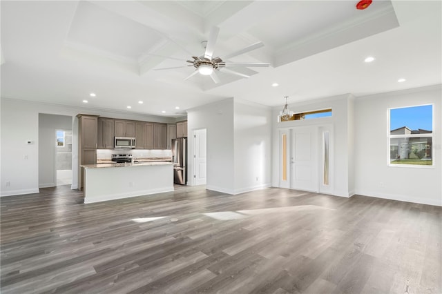 unfurnished living room with dark wood-type flooring, coffered ceiling, plenty of natural light, and baseboards