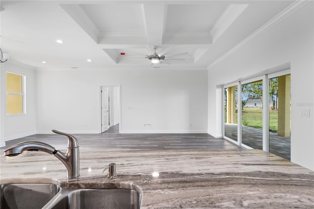 interior space featuring coffered ceiling, ornamental molding, wood finished floors, a sink, and beam ceiling