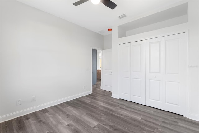 unfurnished bedroom with ceiling fan, dark wood-style flooring, visible vents, baseboards, and a closet