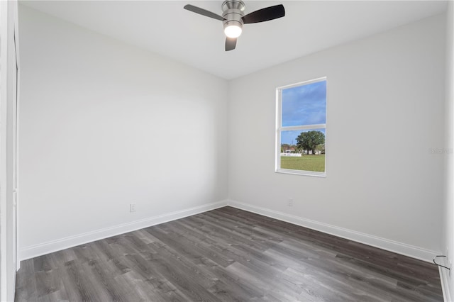 unfurnished room featuring baseboards, dark wood finished floors, and a ceiling fan