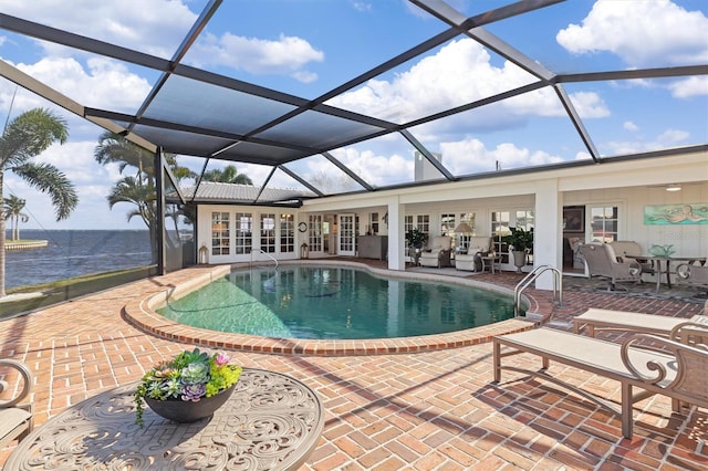 view of swimming pool featuring a lanai, a water view, a patio area, and french doors