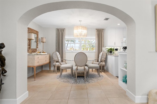 tiled dining room featuring an inviting chandelier