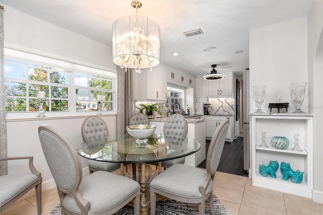 tiled dining area with an inviting chandelier