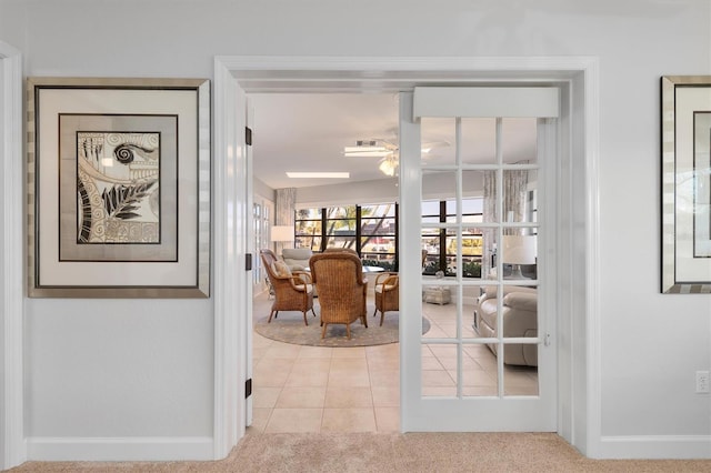 hallway featuring light colored carpet