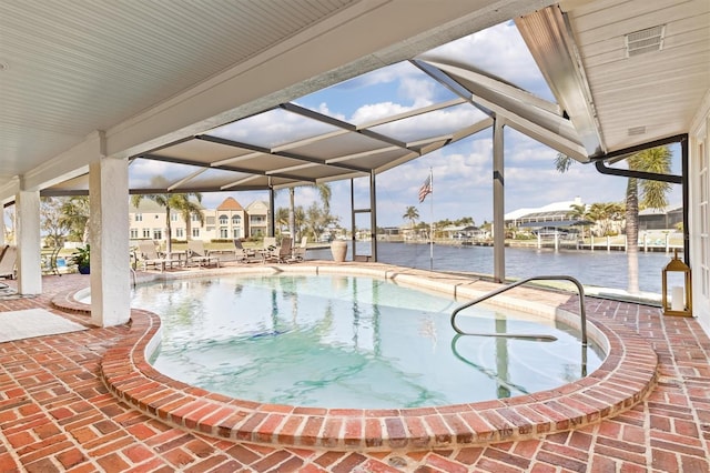 view of swimming pool featuring a lanai, a water view, and a patio