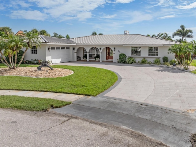 ranch-style home featuring a garage and a front lawn