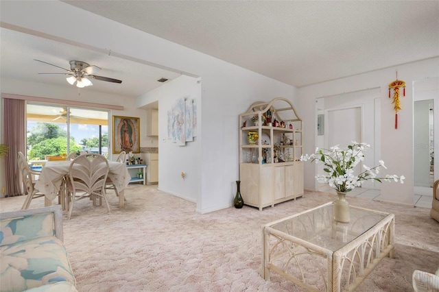 living room with carpet, ceiling fan, and a textured ceiling