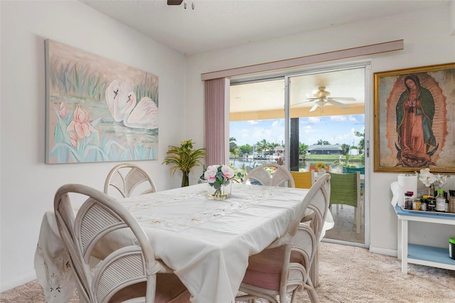 carpeted dining area with ceiling fan