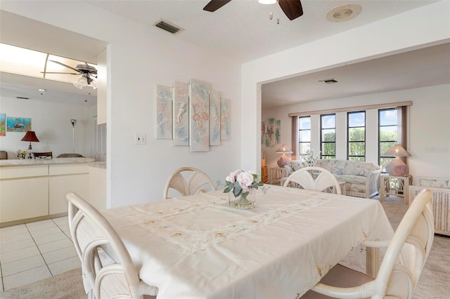 tiled dining room featuring ceiling fan, a textured ceiling, and radiator heating unit