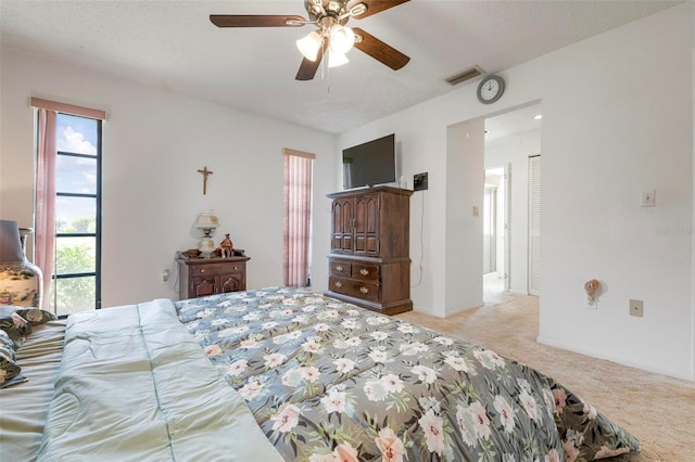 carpeted bedroom featuring a textured ceiling and ceiling fan