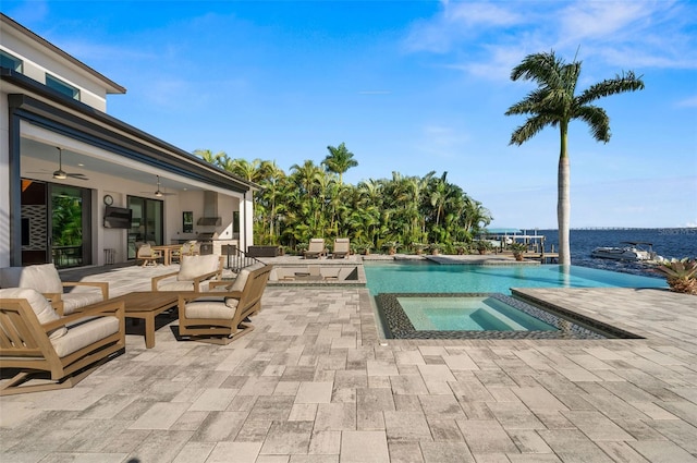 view of swimming pool featuring ceiling fan, a patio area, area for grilling, an in ground hot tub, and a water view