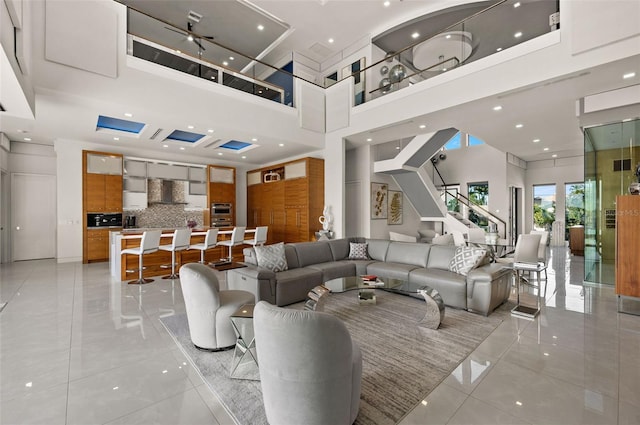 living room featuring light tile patterned floors and a towering ceiling