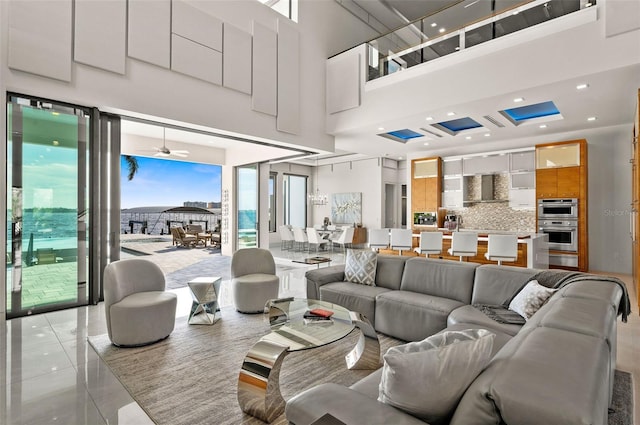 tiled living room with ceiling fan and a towering ceiling