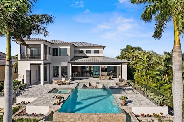 rear view of house with a balcony and a patio area