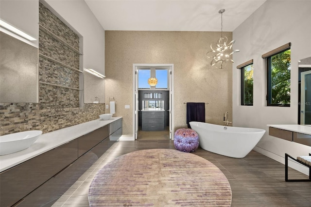 bathroom featuring vanity, tile patterned floors, a chandelier, and a bath