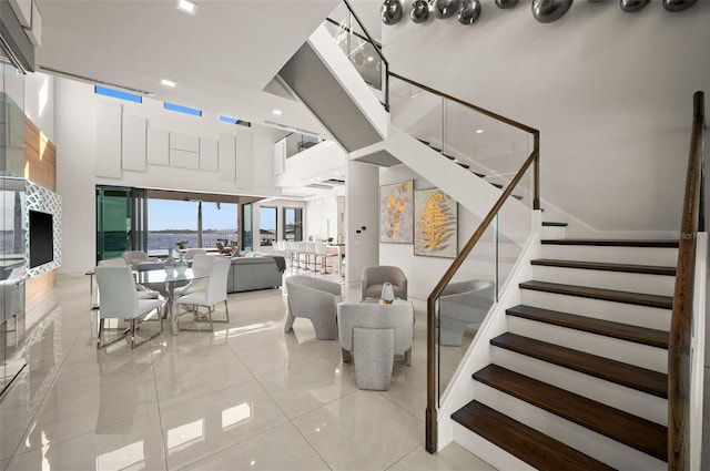 staircase featuring a towering ceiling and tile patterned flooring