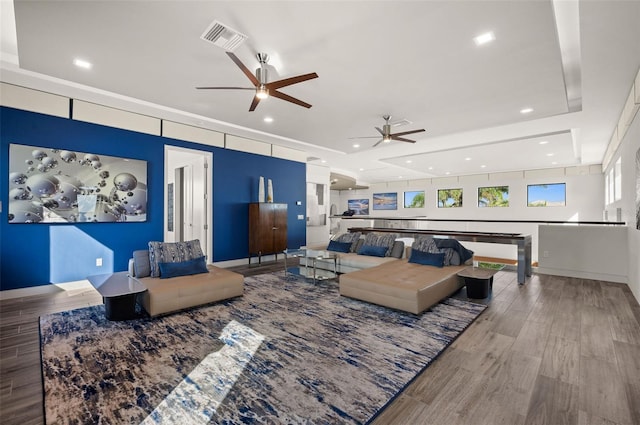 living room with a raised ceiling and hardwood / wood-style flooring