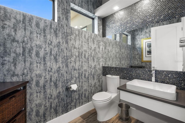 bathroom featuring toilet, tile walls, and vanity