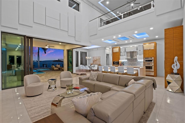 tiled living room featuring ceiling fan and a towering ceiling