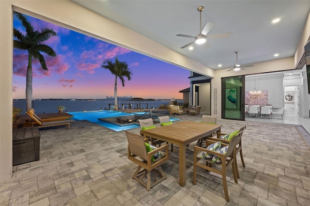 view of patio featuring outdoor dining area, a water view, a fenced in pool, and ceiling fan