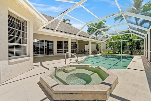 view of pool with a patio area, glass enclosure, and an in ground hot tub