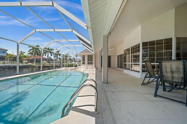 view of pool with a lanai, a water view, and a patio