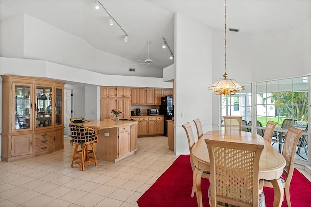 kitchen with light tile patterned floors, decorative light fixtures, high vaulted ceiling, a kitchen island, and ceiling fan with notable chandelier