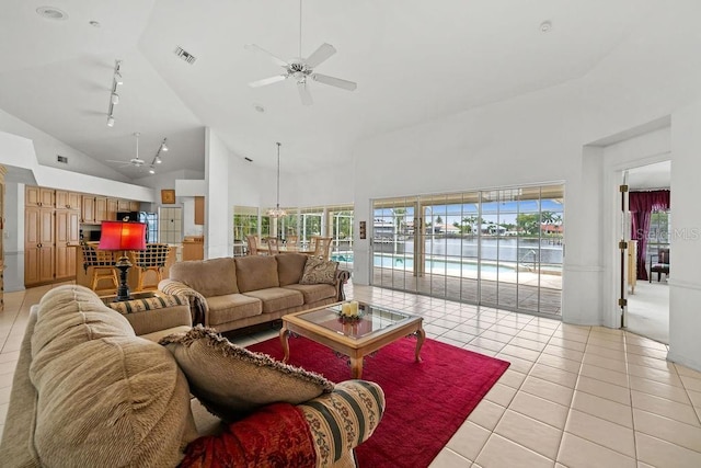 tiled living room with high vaulted ceiling, rail lighting, and ceiling fan