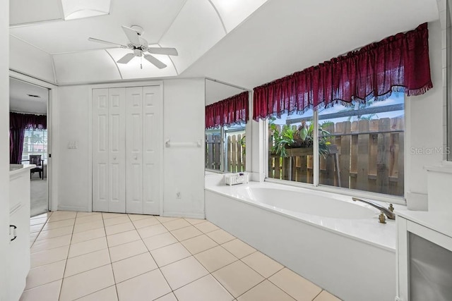 bathroom with ceiling fan, tile patterned floors, and lofted ceiling