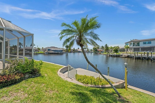 exterior space featuring a lanai, a lawn, and a water view