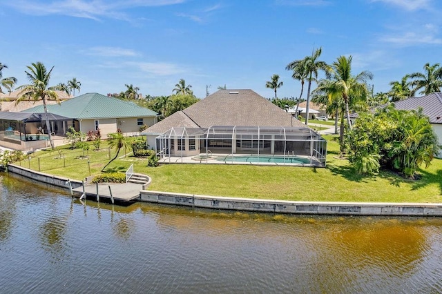 back of house with glass enclosure, a lawn, and a water view