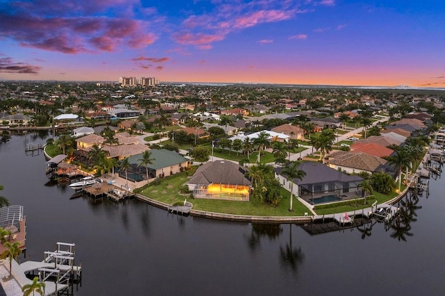 aerial view at dusk featuring a water view