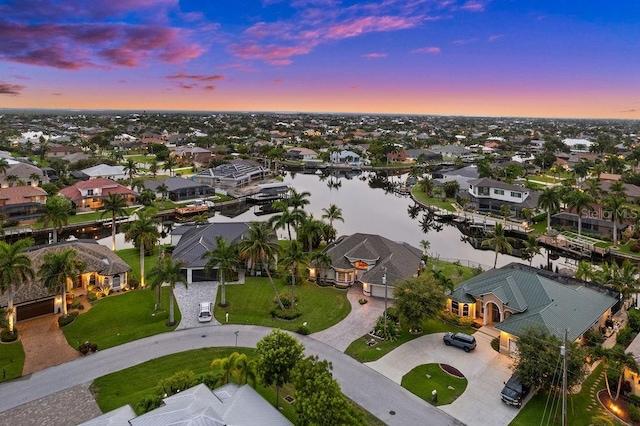 aerial view at dusk featuring a water view