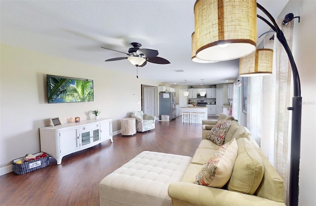 living room with ceiling fan and dark hardwood / wood-style floors