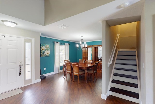 dining space featuring crown molding, dark hardwood / wood-style floors, and an inviting chandelier