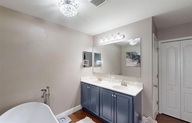 bathroom with vanity, wood-type flooring, and a tub