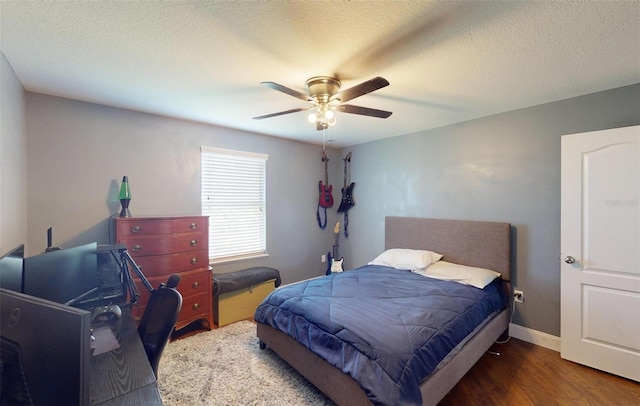 bedroom featuring ceiling fan, dark hardwood / wood-style floors, and a textured ceiling