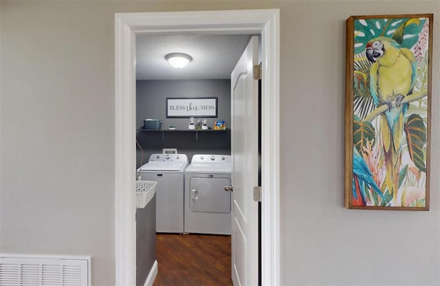 washroom with dark wood-type flooring, separate washer and dryer, and a textured ceiling