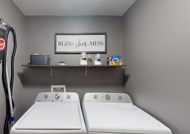 washroom featuring a textured ceiling and washer and clothes dryer