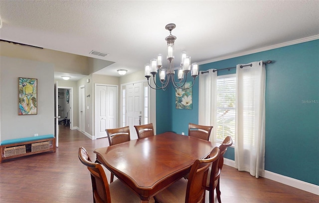 dining space with ornamental molding, dark hardwood / wood-style flooring, and a chandelier