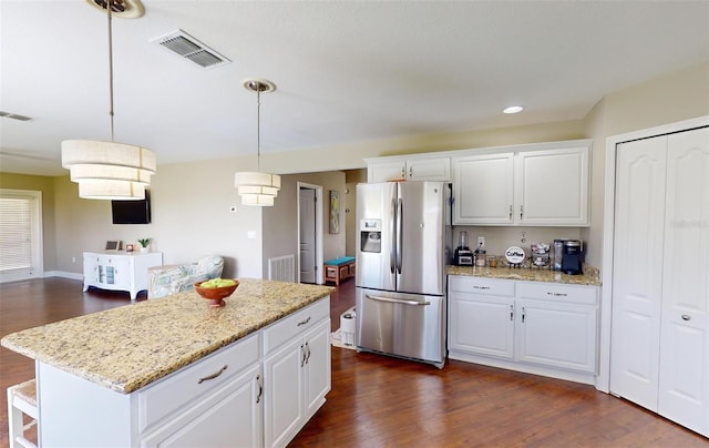 kitchen with a kitchen island, pendant lighting, white cabinets, and stainless steel fridge with ice dispenser