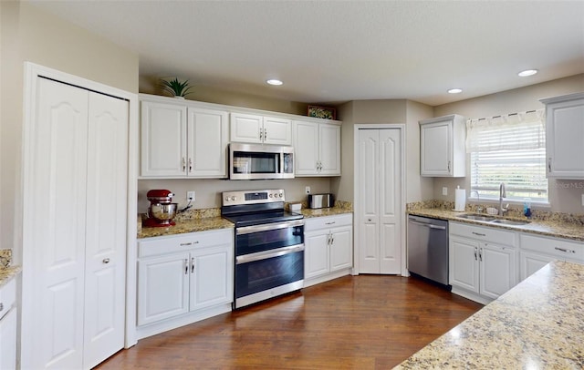 kitchen with sink, stainless steel appliances, dark hardwood / wood-style floors, and white cabinets