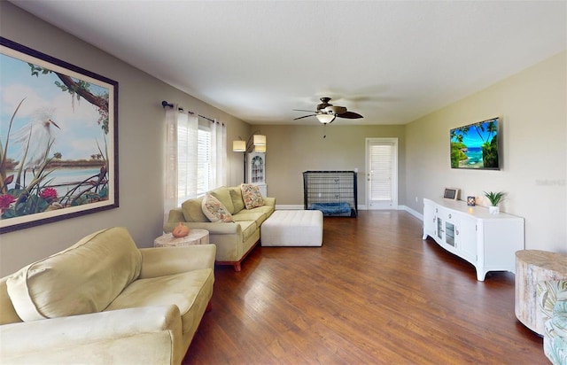 living room featuring dark wood-type flooring and ceiling fan