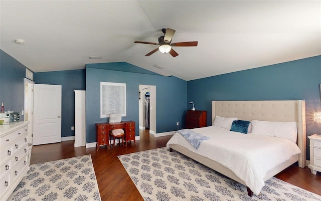 bedroom featuring lofted ceiling, a walk in closet, dark hardwood / wood-style floors, a closet, and ceiling fan