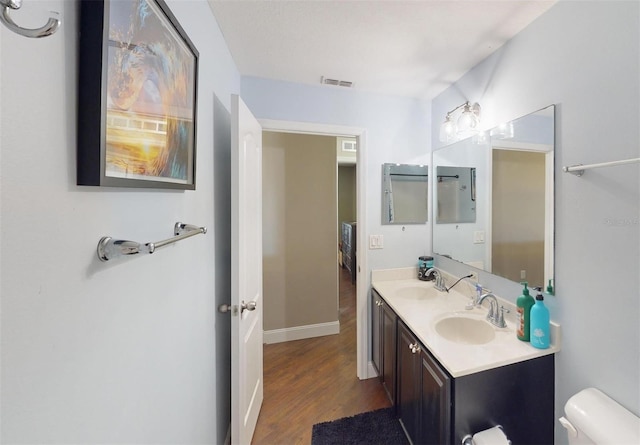 bathroom with vanity, hardwood / wood-style flooring, and toilet