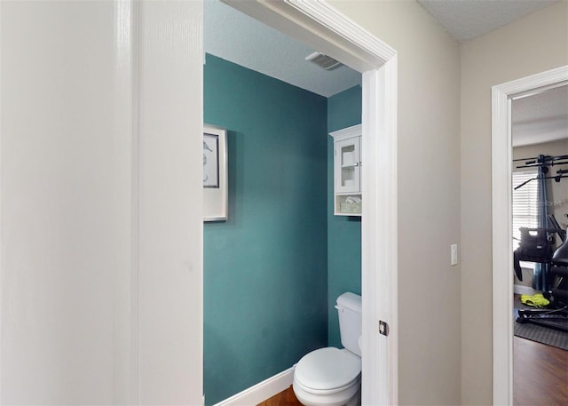 bathroom with hardwood / wood-style floors and toilet