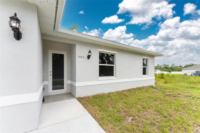 entrance to property with a lawn