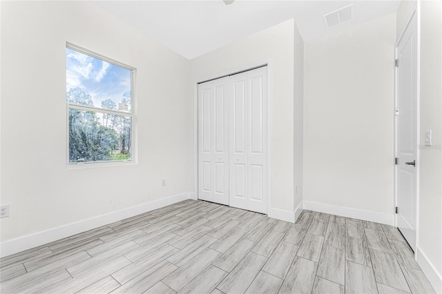 unfurnished bedroom featuring light hardwood / wood-style flooring and a closet