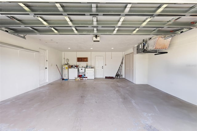 garage with a garage door opener, independent washer and dryer, and electric water heater