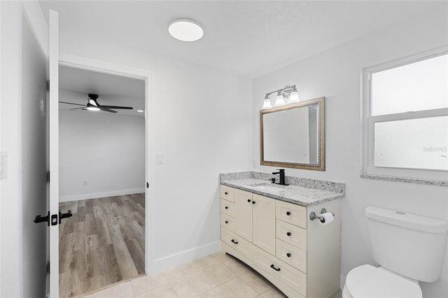 bathroom featuring toilet, vanity, wood-type flooring, and ceiling fan